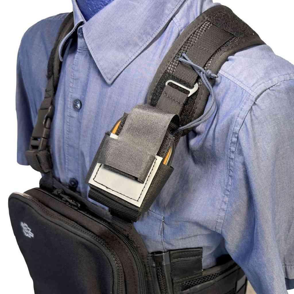 Person wearing a tactical vest with a shoulder holster on a white background